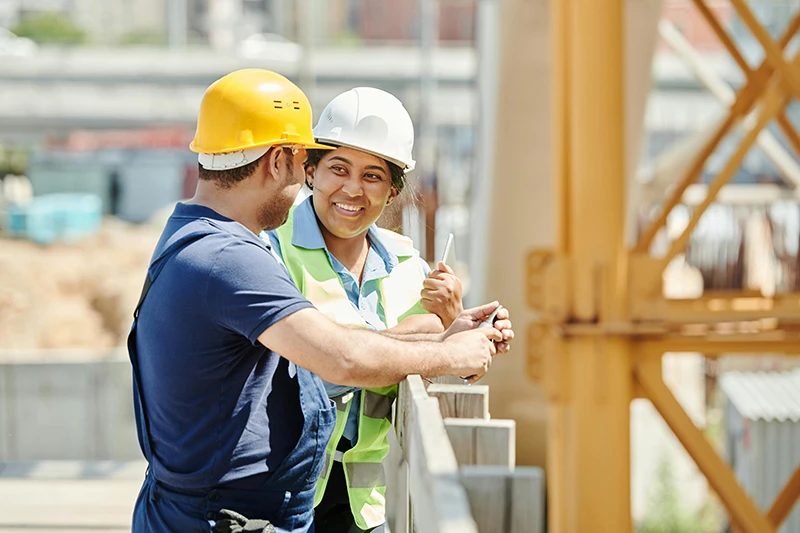 Construction workers discussing work on a building site during civil engineering operations training